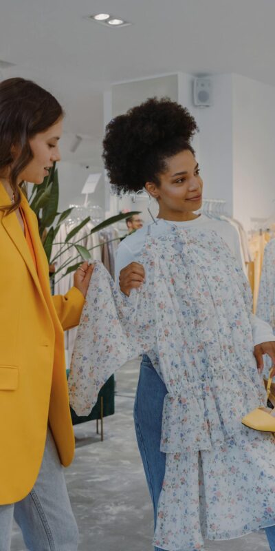 Two women shopping for stylish clothing in a modern fashion boutique.