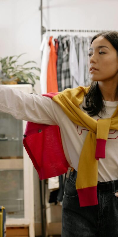 Woman shopping for sneakers in a stylish vintage clothing store, browsing multiple options.